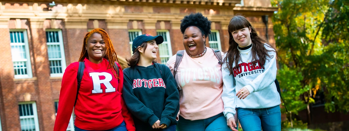 (L to R) Jhunie Clerveus (SEBS '24), Jamie Oliver (SAS '26), Madison Griffin (SAS '26), and Lily Rudd (SAS '26), walk outside Murray Hall on the College Avenue campus